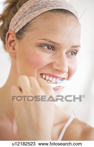 Studio portrait of woman brushing teeth View Large Photo Image Stock Image - Studio portrait of woman brushing teeth. Fotosearch