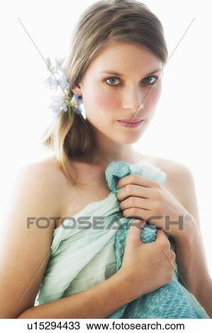 Stock Image - Studio portrait of young woman holding towel. Fotosearch