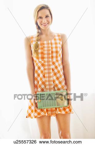 Studio portrait of young woman holding antique radio View Large Photo Image Stock Photograph - Studio portrait of young woman holding antique radio. Fotosearch