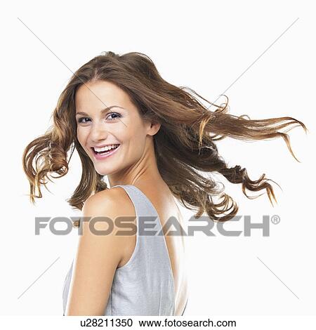 Studio portrait of young woman smiling and looking over shoulder View Large Photo Image Stock Image - Studio portrait of young woman smiling and looking over shoulder. Fotosearch