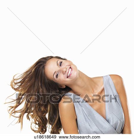 Stock Photo - Studio portrait of young woman tilting her head and smiling. Fotosearch