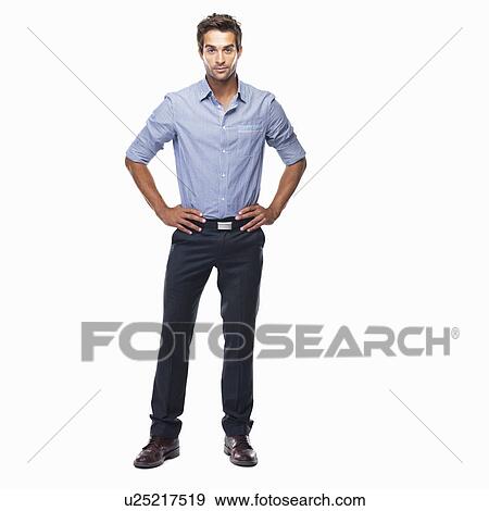 Stock Photo - Studio shot of attractive business man standing with hands on hips. Fotosearch