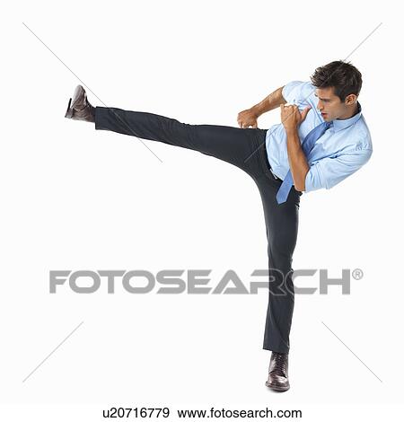Studio shot of business man delivering high side kick View Large Photo Image Stock Photo - Studio shot of business man delivering high side kick. Fotosearch