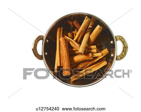 Stock Image - Studio shot of Cinnamon Sticks in pan on white background. Fotosearch