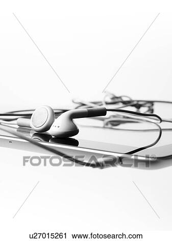 Stock Image - Studio shot of digital tablet and earphones. Fotosearch