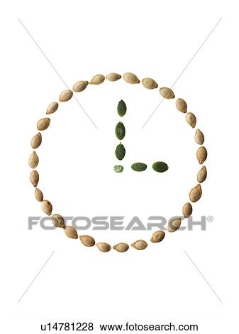 Stock Photo - Studio shot of Pumpkin Seeds in shape of clock on white background. Fotosearch