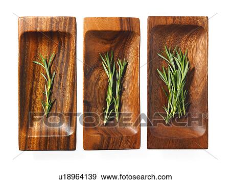 Stock Photo - Studio shot of rosemary on wooden trays. Fotosearch