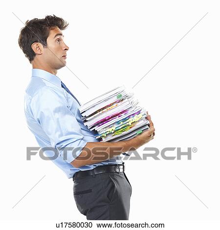 Stock Image - Studio shot of smart business man carrying heavy documents. Fotosearch