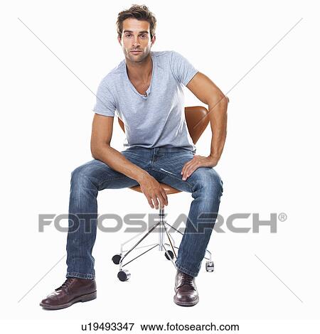 Studio shot of smart young man sitting on chair View Large Photo Image Stock Photo - Studio shot of smart young man sitting on chair. Fotosearch