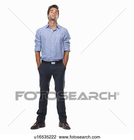 Stock Image - Studio shot of young business man standing with hands in pockets. Fotosearch