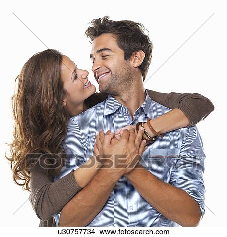 Studio shot of young couple smiling and looking at each other View Large Photo Image Picture - Studio shot of young couple smiling and looking at each other . Fotosearch