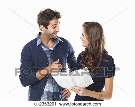 Studio shot of young couple with newspaper smiling and looking at each other View Large Photo Image Stock Image - Studio shot of young couple with newspaper smiling and looking at each other. Fotosearch