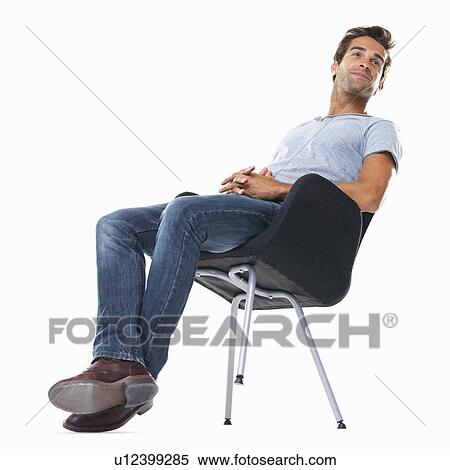 Studio shot of young man balancing on chair View Large Photo Image Stock Photography - Studio shot of young man balancing on chair. Fotosearch