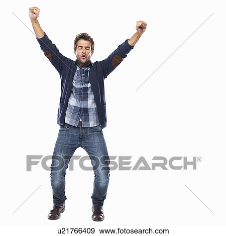 Stock Photo - Studio shot of young man celebrating with arms raised. Fotosearch
