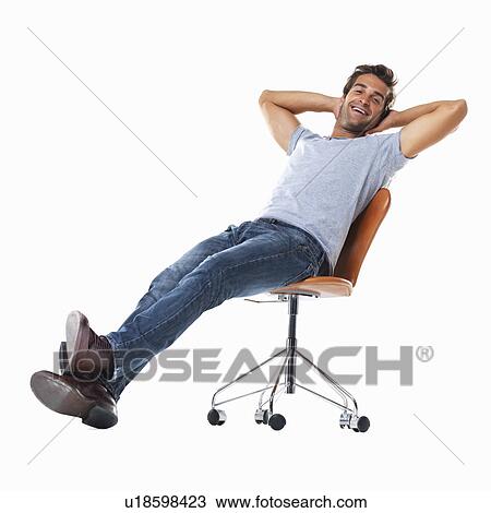 Stock Image - Studio shot of young man relaxing on chair. Fotosearch