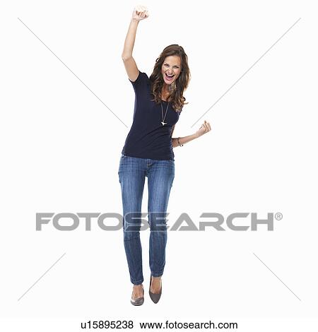Stock Photo - Studio shot of young woman celebrating with arm raised. Fotosearch