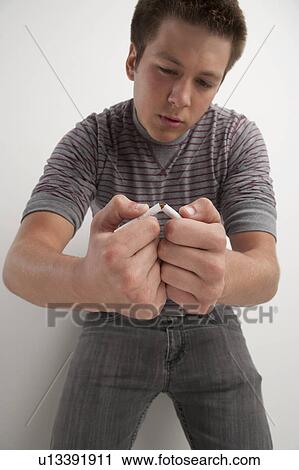 Teenage boy (16-17) breaking cigarette, studio shot View Large Photo Image Stock Image - Teenage boy (16-17) breaking cigarette, studio shot. Fotosearch