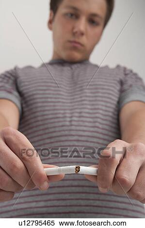 Teenage boy (16-17) breaking cigarette, studio shot View Large Photo Image Stock Photography - Teenage boy (16-17) breaking cigarette, studio shot. Fotosearch