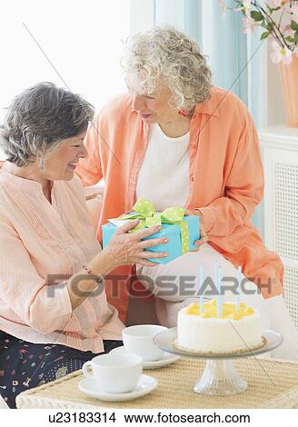 Picture - Two senior women celebrating birthday. Fotosearch