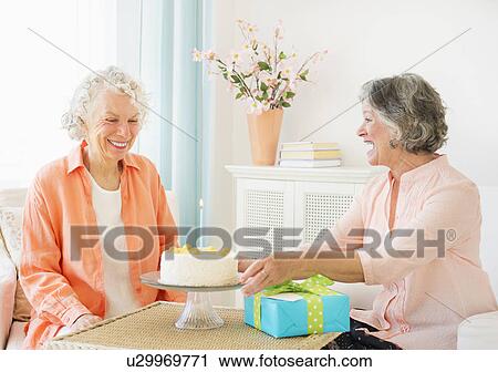 Stock Image - Two senior women celebrating birthday. Fotosearch
