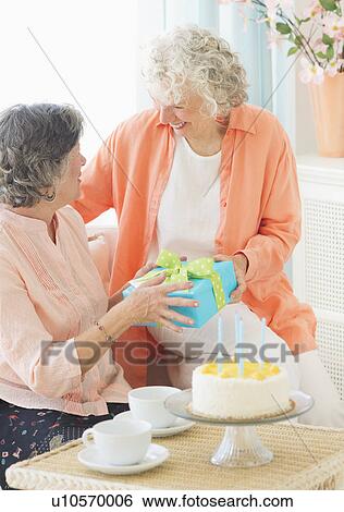 Two senior women celebrating birthday View Large Photo Image Stock Photograph - Two senior women celebrating birthday. Fotosearch