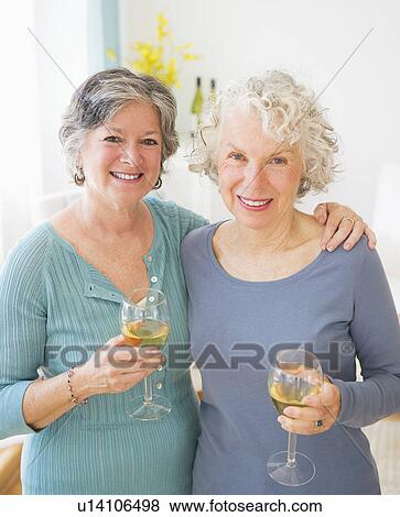 Two senior women holding wine glasses View Large Photo Image Stock Photo - Two senior women holding wine glasses. Fotosearch