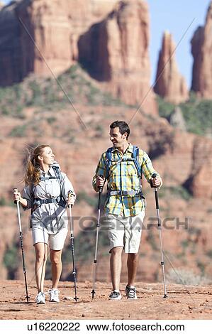 Stock Image - USA, Arizona, Sedona, Young couple hiking in desert. Fotosearch