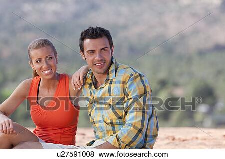 Stock Photo - USA, Arizona, Sedona, Young couple enjoying view in desert after hiking. Fotosearch