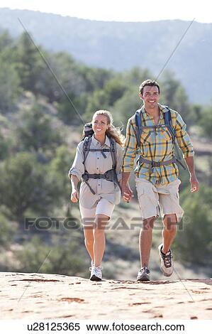 Stock Photography - USA, Arizona, Sedona, Young couple hiking in desert. Fotosearch