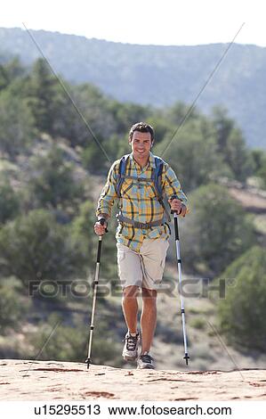 Stock Image - USA, Arizona, Sedona, Young man hiking in desert. Fotosearch