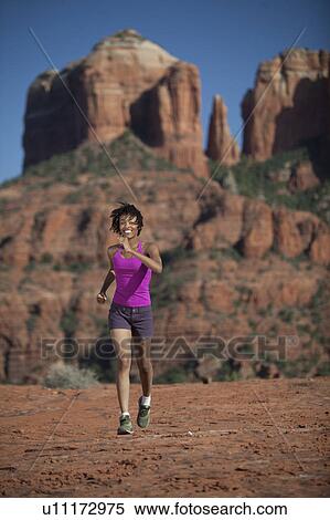 Stock Photography - USA, Arizona, Sedona, Young woman running at desert. Fotosearch