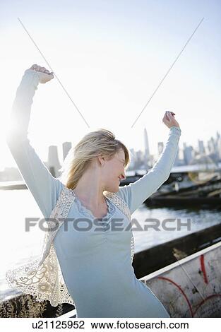 USA, Brooklyn, Williamsburg, Portrait of blonde woman stretching arms in backlit View Large Photo Image Stock Image - USA, Brooklyn, Williamsburg, Portrait of blonde woman stretching arms in backlit. Fotosearch