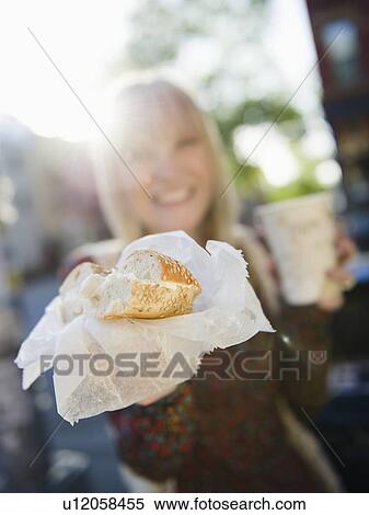 Stock Photography - USA, Brooklyn, Williamsburg, Woman showing bagel. Fotosearch