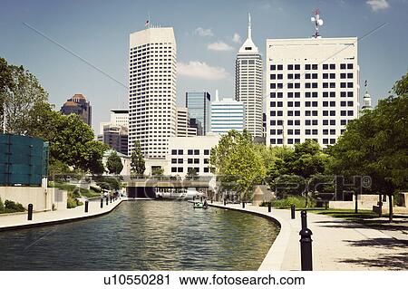 Stock Image - USA, Indiana, Indianapolis, View of canal and skyscrapers. Fotosearch