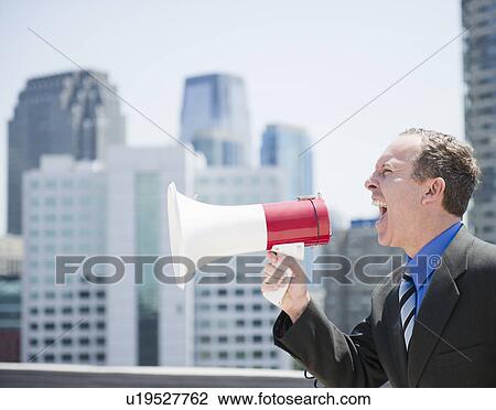 USA, New Jersey, Jersey City, Businessman shouting through megaphone View Large Photo Image Stock Image - USA, New Jersey, Jersey City, Businessman shouting through megaphone. Fotosearch