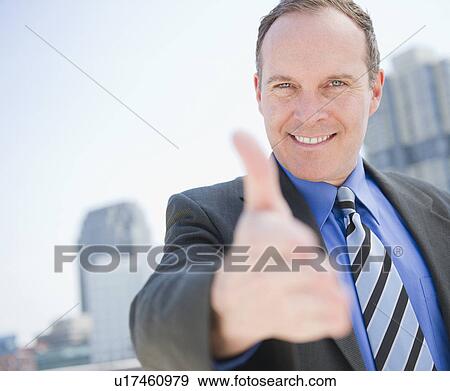 Stock Photo - USA, New Jersey, Jersey City, Businessman showing thumbs up. Fotosearch