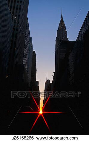 Stock Photograph - USA, New York, Manhattan, City buildings at sunset with sunbeam. Fotosearch