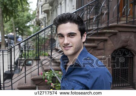 USA, New York, New York City, Portrait of smiling young man on street View Large Photo Image Picture - USA, New York, New York City, Portrait of smiling young man on street. Fotosearch
