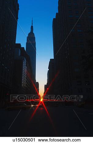 Stock Image - USA, New York, New York City, Silhouette of Empire State Building and street. Fotosearch