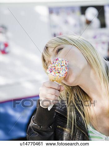 Stock Image - USA, New York, Williamsburg, Brooklyn, Blonde woman licking ice cream. Fotosearch