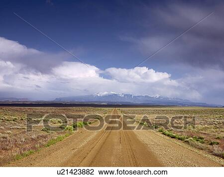 Stock Image - USA, Utah, Dirt road crossing landscape. Fotosearch
