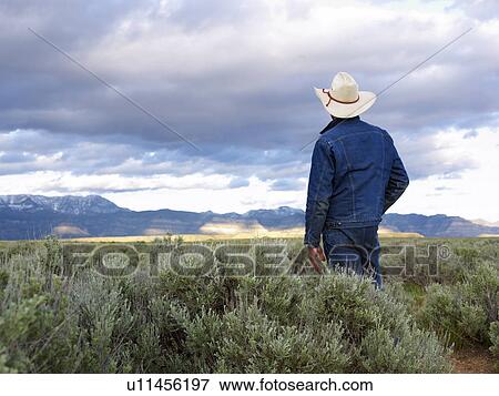 Stock Photo - USA, Utah, Rear view of man standing in desert landscape. Fotosearch