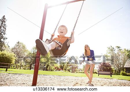 USA, Washington State, Seattle, Mother and son (2-3) swinging on swing in park View Large Photo Image Picture - USA, Washington State, Seattle, Mother and son (2-3) swinging on swing in park. Fotosearch