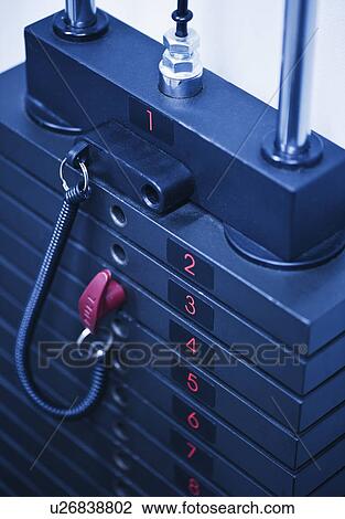 Stock Image - Weights on exercise machine in gym. Fotosearch