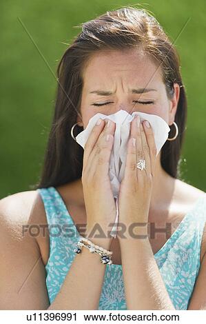 Stock Image - Woman blowing nose. Fotosearch