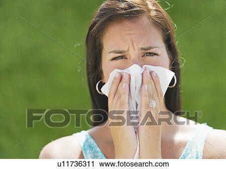 Stock Image - Woman blowing nose. Fotosearch