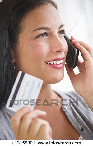 Woman holding credit card and phone View Large Photo Image Stock Image - Woman holding credit card and phone. Fotosearch