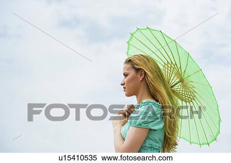 Stock Photography - Woman holding parasol. Fotosearch