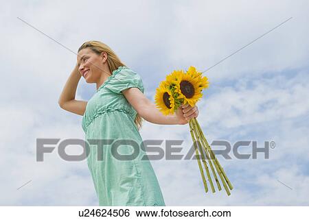 Woman holding sunflowers View Large Photo Image Stock Photograph - Woman holding sunflowers. Fotosearch