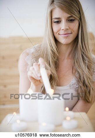 Woman igniting candles in spa View Large Photo Image Stock Photo - Woman igniting candles in spa. Fotosearch